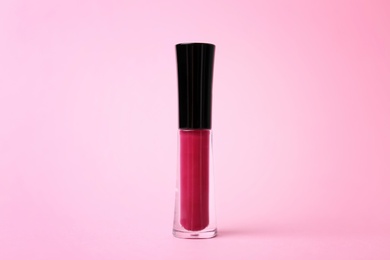 Beautiful lip gloss on color background