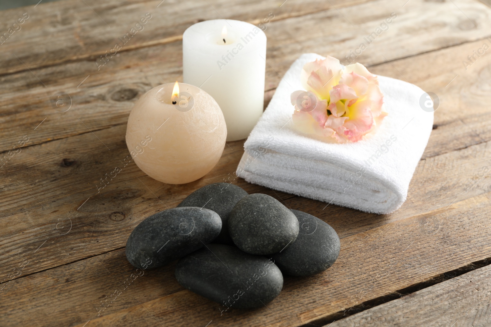 Photo of Composition with spa stones on wooden table