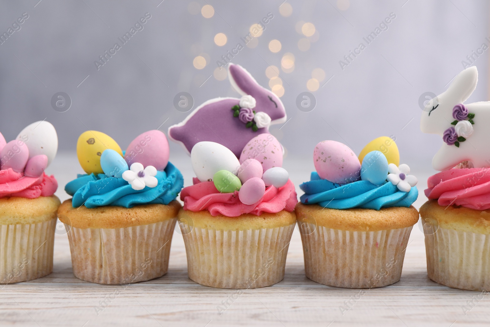 Photo of Tasty decorated Easter cupcakes on wooden table