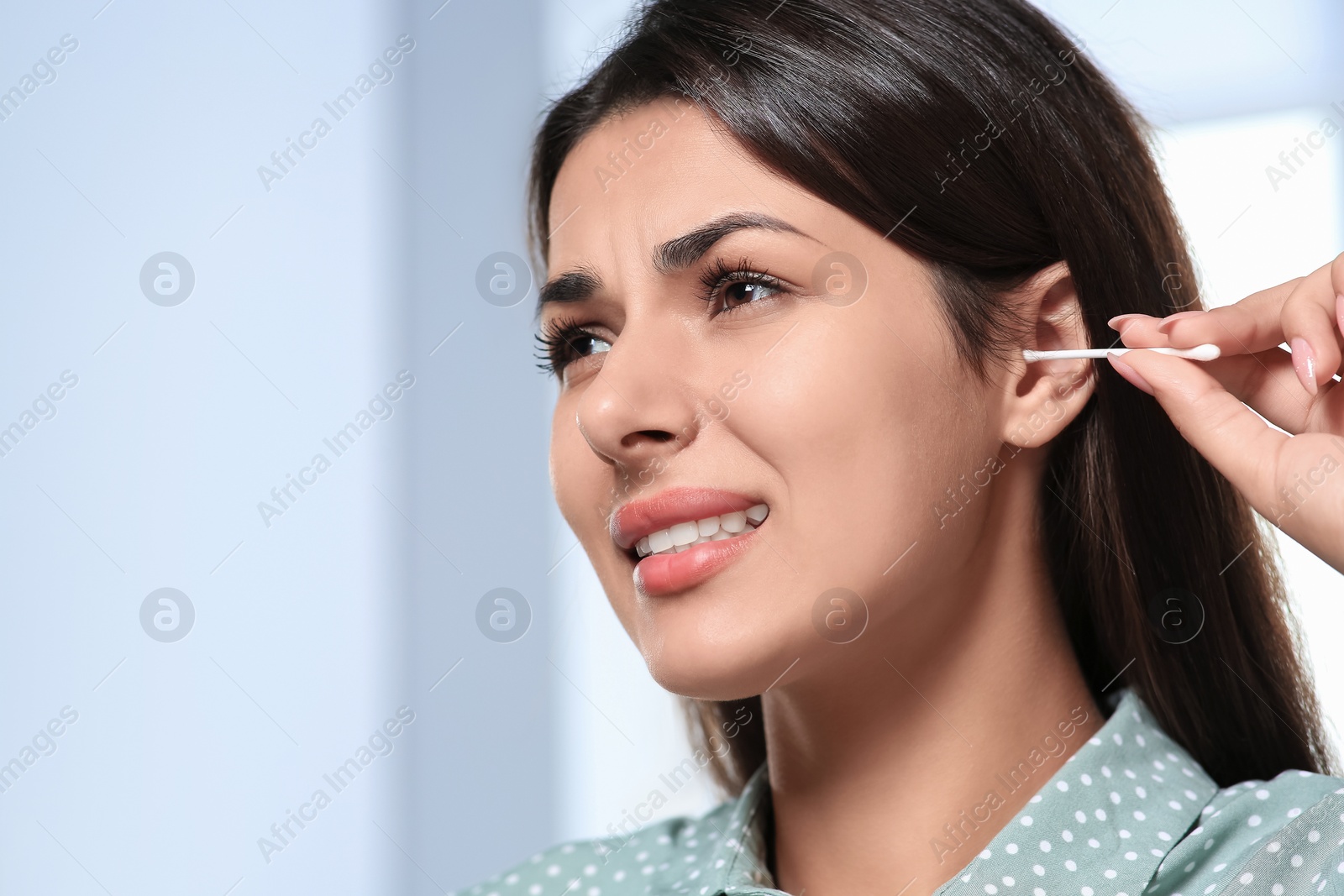 Photo of Young woman cleaning ear with cotton swab, closeup. Space for text