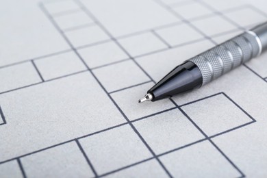 Pen on blank crossword, closeup. Space for text
