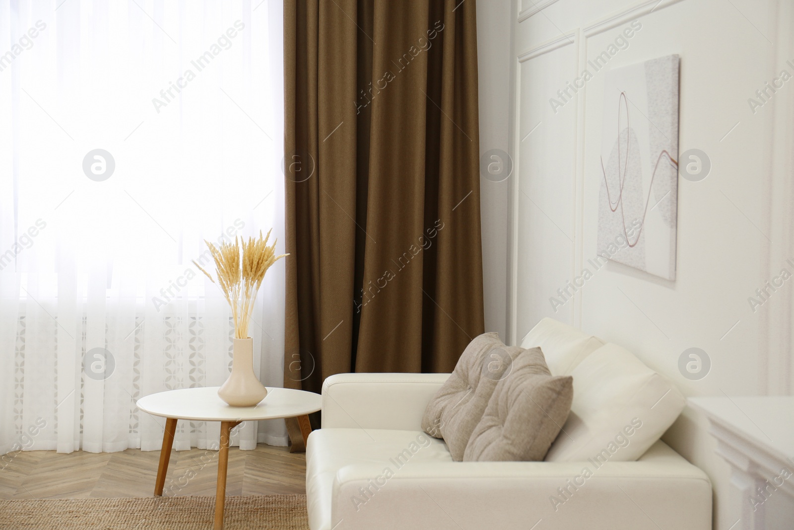 Photo of Sofa and window with brown curtains in simple room interior