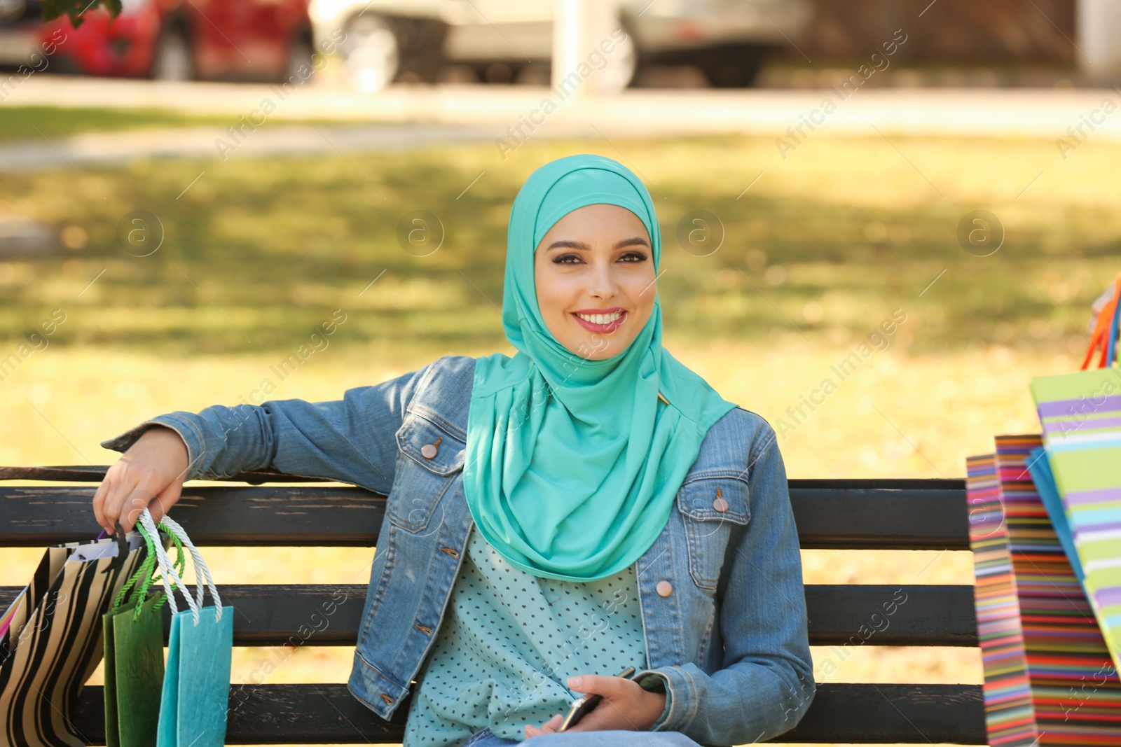 Photo of Muslim woman sitting on bench in park