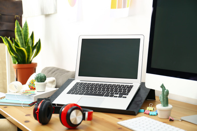 Photo of Modern laptop, computer and office supplies on wooden table, space for text. Designer's workplace