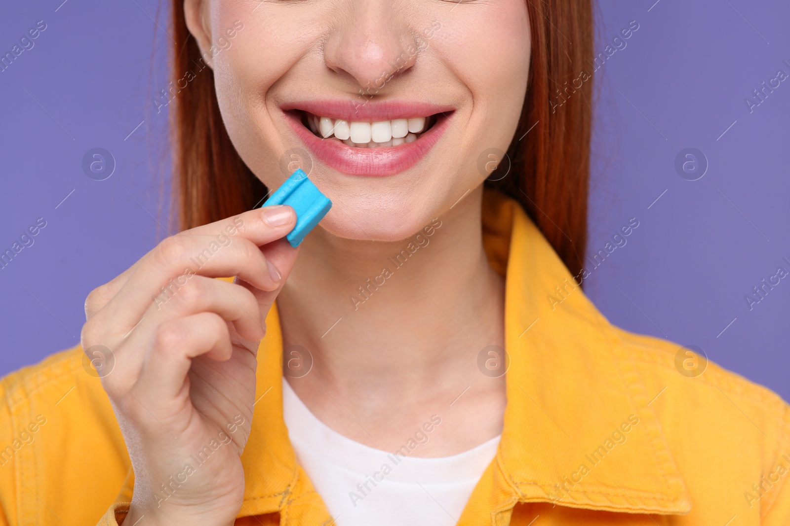 Photo of Woman with bubble gum on purple background, closeup