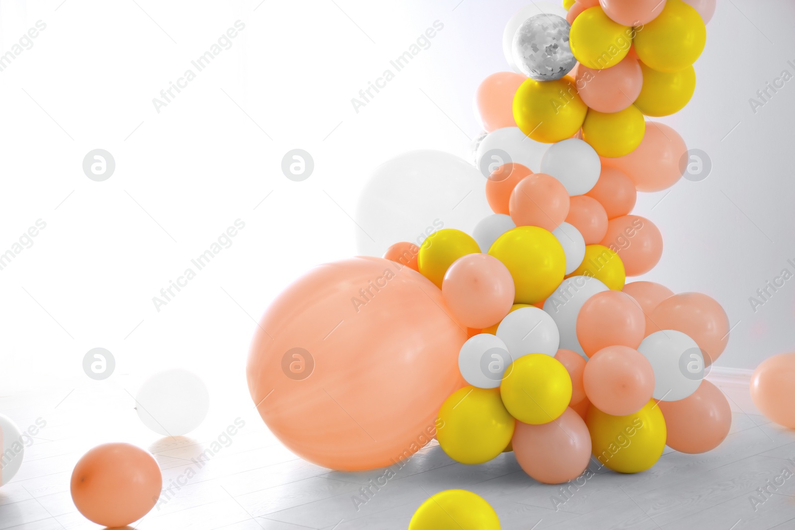 Image of Balloon garland near white wall in room. Festive decor