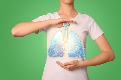 Image of Woman holding hands near chest with illustration of lungs on green background, closeup