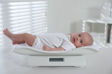 Cute little baby lying on scales in clinic