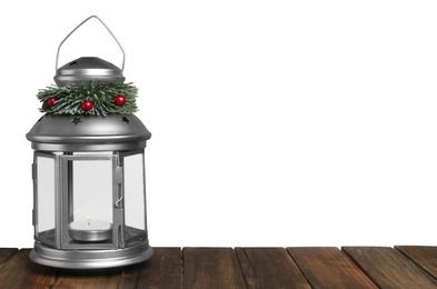 Photo of Christmas lantern decorated with coniferous twig and berries on grey background. Space for text