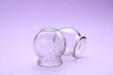 Photo of Glass cups on violet background. Cupping therapy