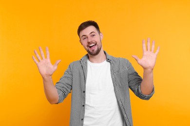 Man giving high five with both hands on yellow background