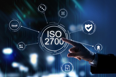Image of Man pointing at virtual screen with text ISO 2700 and different icons, closeup