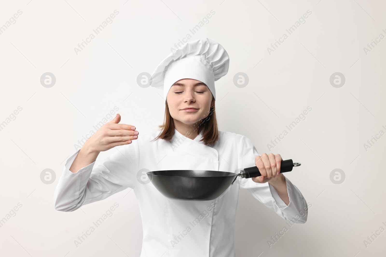 Photo of Professional chef with frying pan on light background