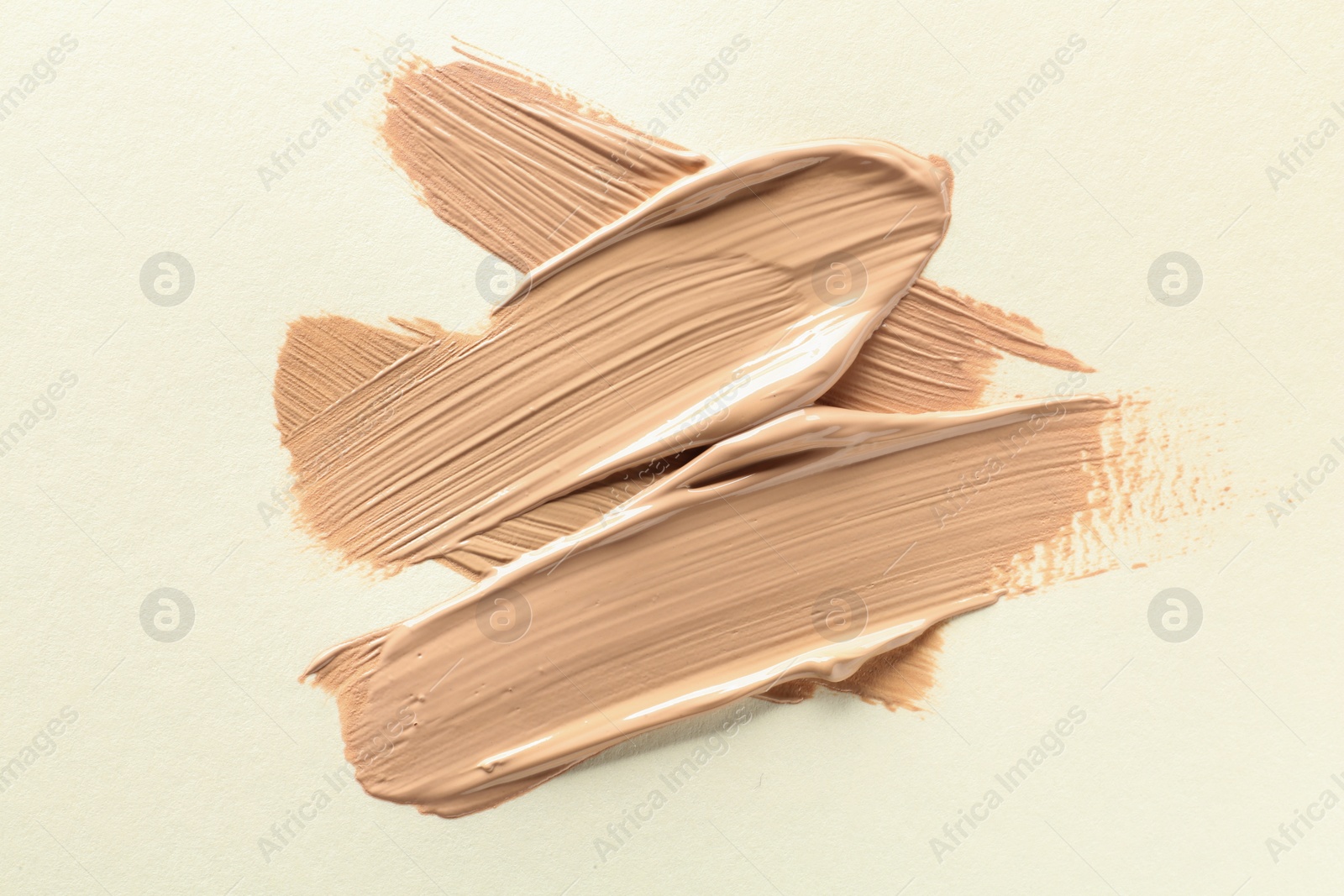 Photo of Sample of liquid skin foundation on beige background, top view