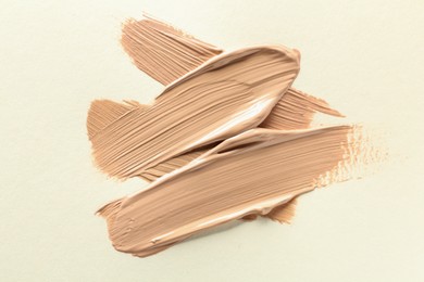 Photo of Sample of liquid skin foundation on beige background, top view