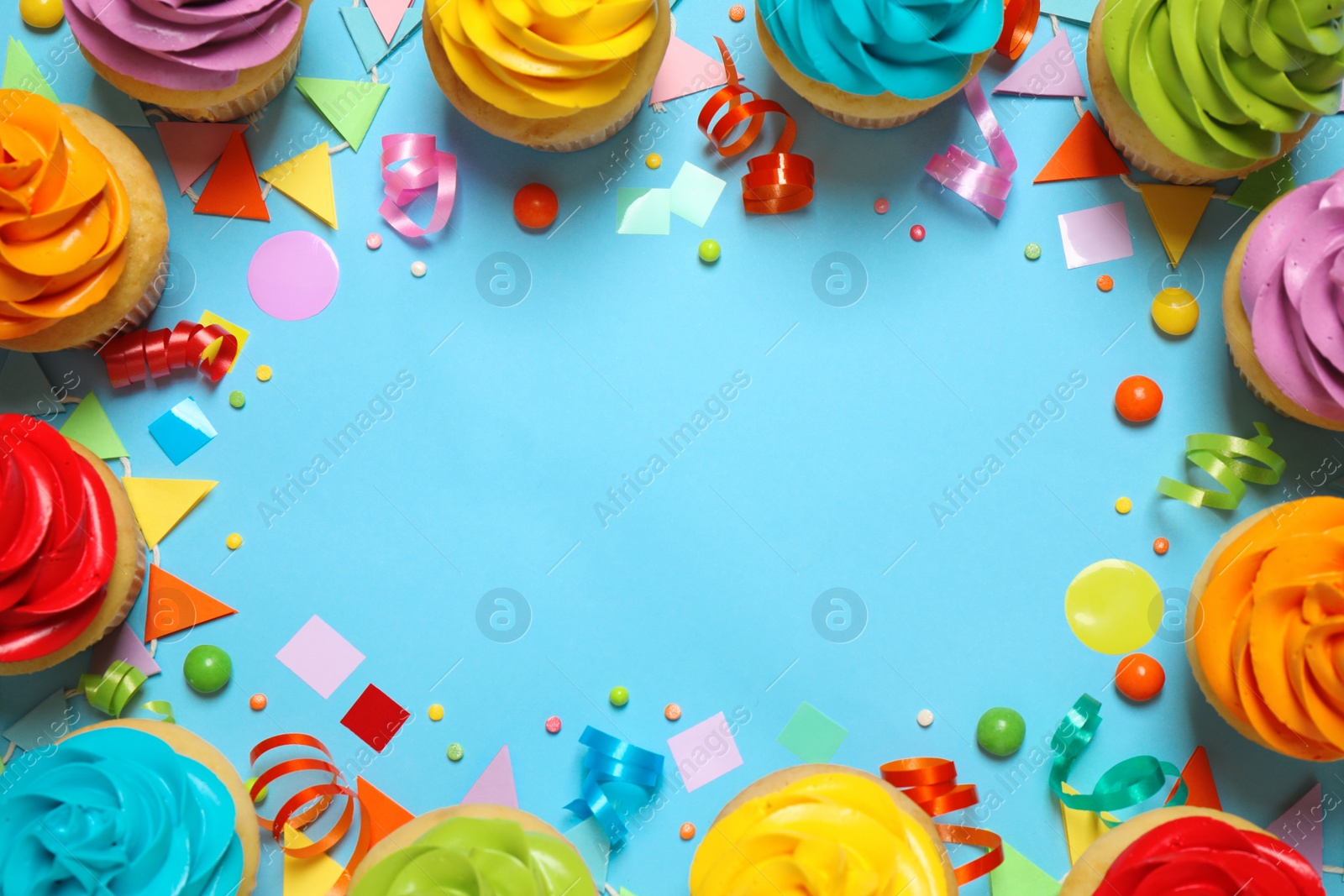 Photo of Colorful birthday cupcakes on light blue background, flat lay. Space for text