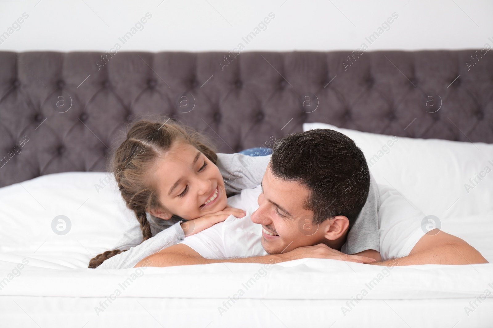 Photo of Father with his cute child in bedroom. Happy family