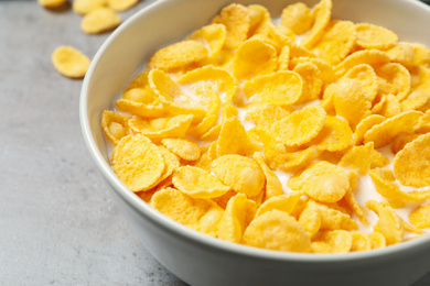 Tasty corn flakes with milk on light grey table, closeup