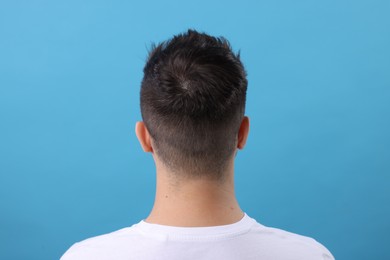 Photo of Man with healthy hair on light blue background, back view