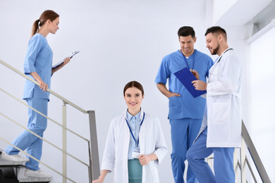 Photo of Team of professional doctors on staircase in clinic