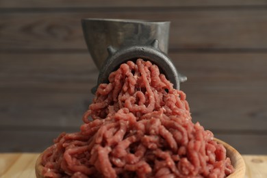 Mincing beef with manual meat grinder on table, closeup