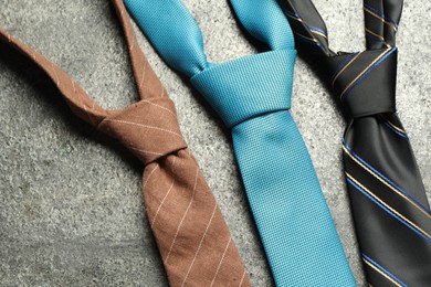 Photo of Different neckties on grey textured background, flat lay