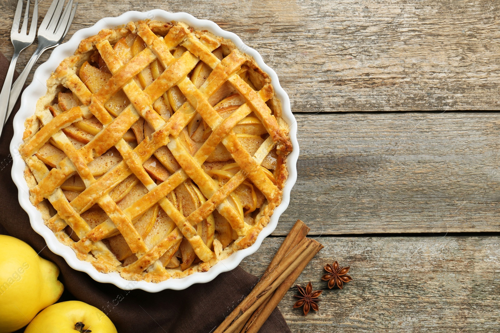 Photo of Tasty homemade quince pie served on wooden table, flat lay. Space for text