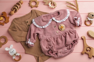 Photo of Flat lay composition with baby clothes and accessories on pink wooden background