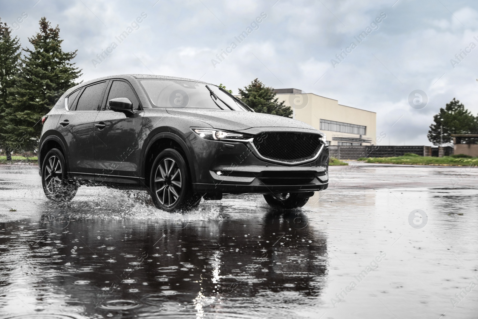 Photo of Modern car driving outdoors on rainy day