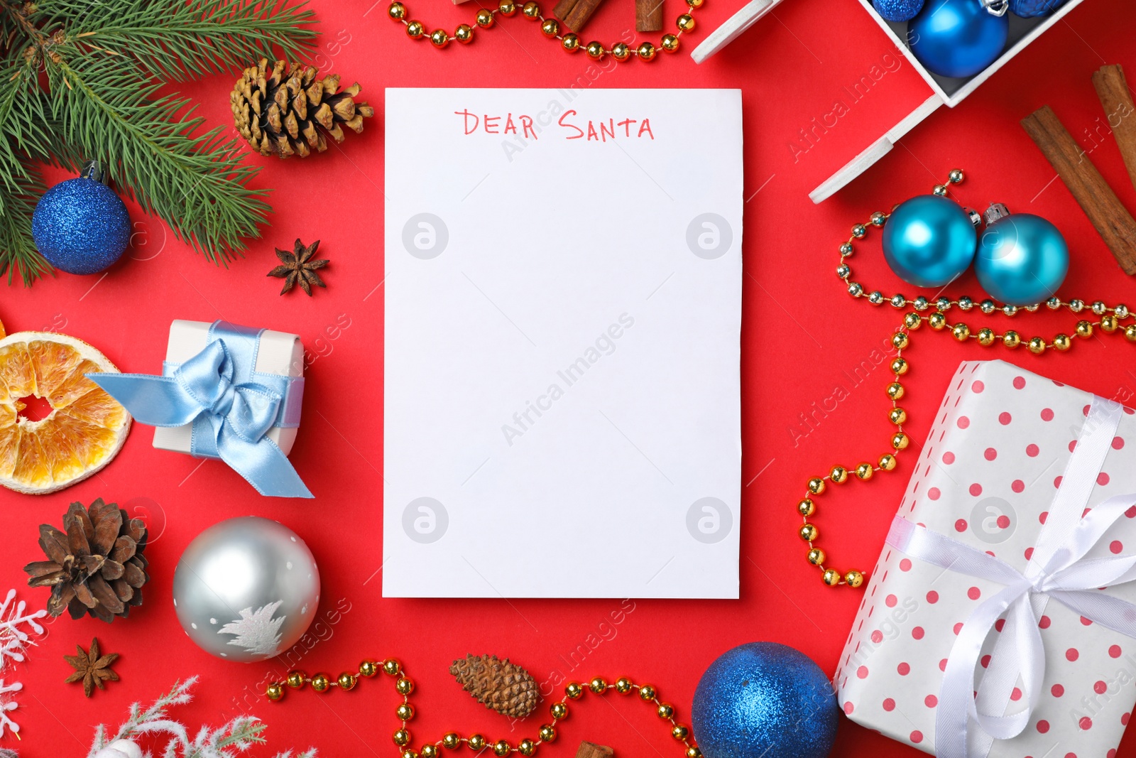 Photo of Flat lay composition with paper and Christmas decor on color background. Letter for Santa Claus