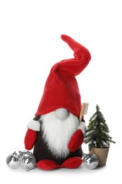 Photo of Funny Christmas gnome with tree and baubles on white background