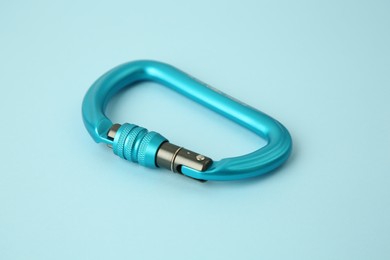 One carabiner on light blue background, closeup