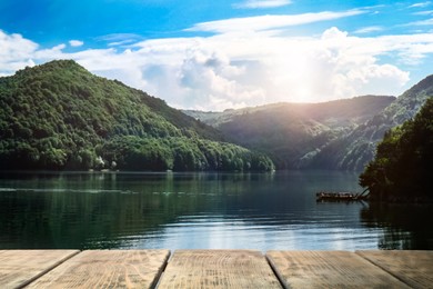 Beautiful view of mountains and wooden pier near lake on sunny day