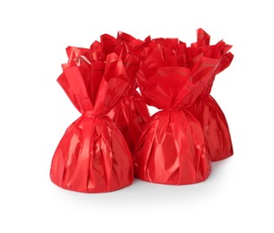 Photo of Delicious candies in red wrappers on white background