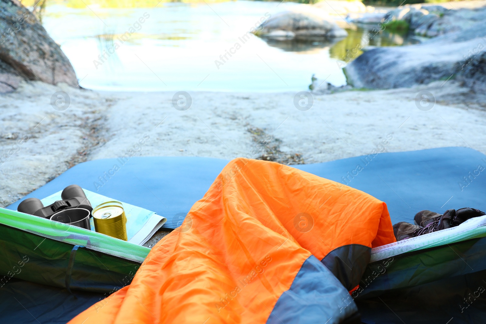 Photo of Camping tent with sleeping bag near lake, view from inside