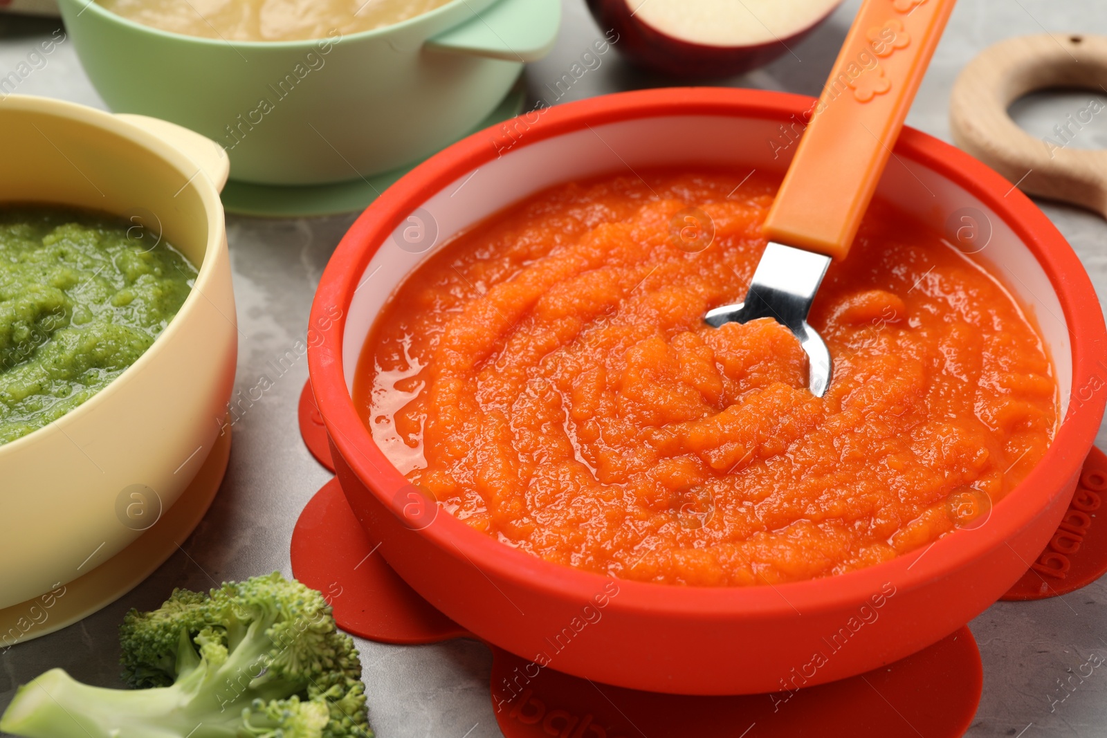 Photo of Healthy baby food. Different tasty puree in bowls on light grey table, closeup