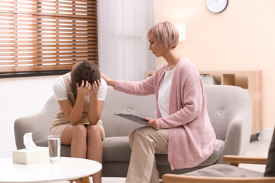 Psychotherapist working with teenage girl in office