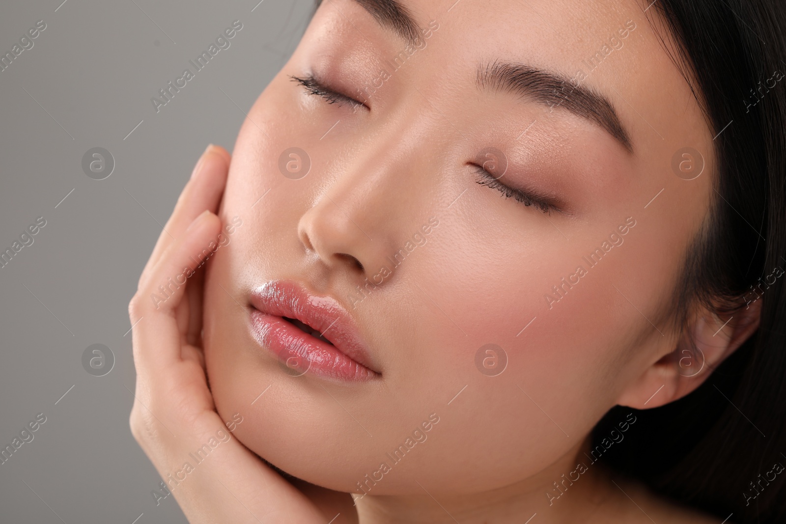 Photo of Beautiful woman with healthy skin on gray background, closeup