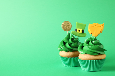 Decorated cupcakes on green background, space for text. St. Patrick's Day celebration