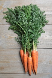 Photo of Fresh carrots on wooden table, top view