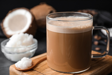 Photo of Delicious coffee with organic coconut oil on grey table