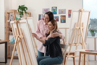 Artist teaching her student to paint in studio. Creative hobby