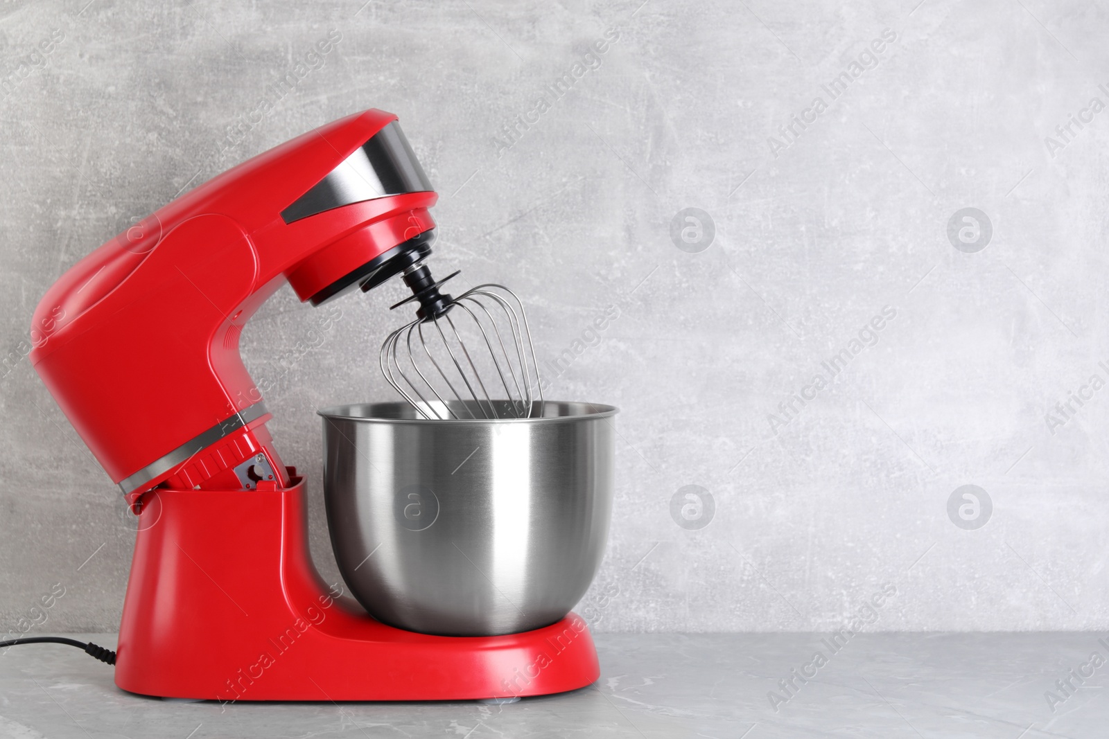 Photo of Modern red stand mixer on light gray marble table, space for text