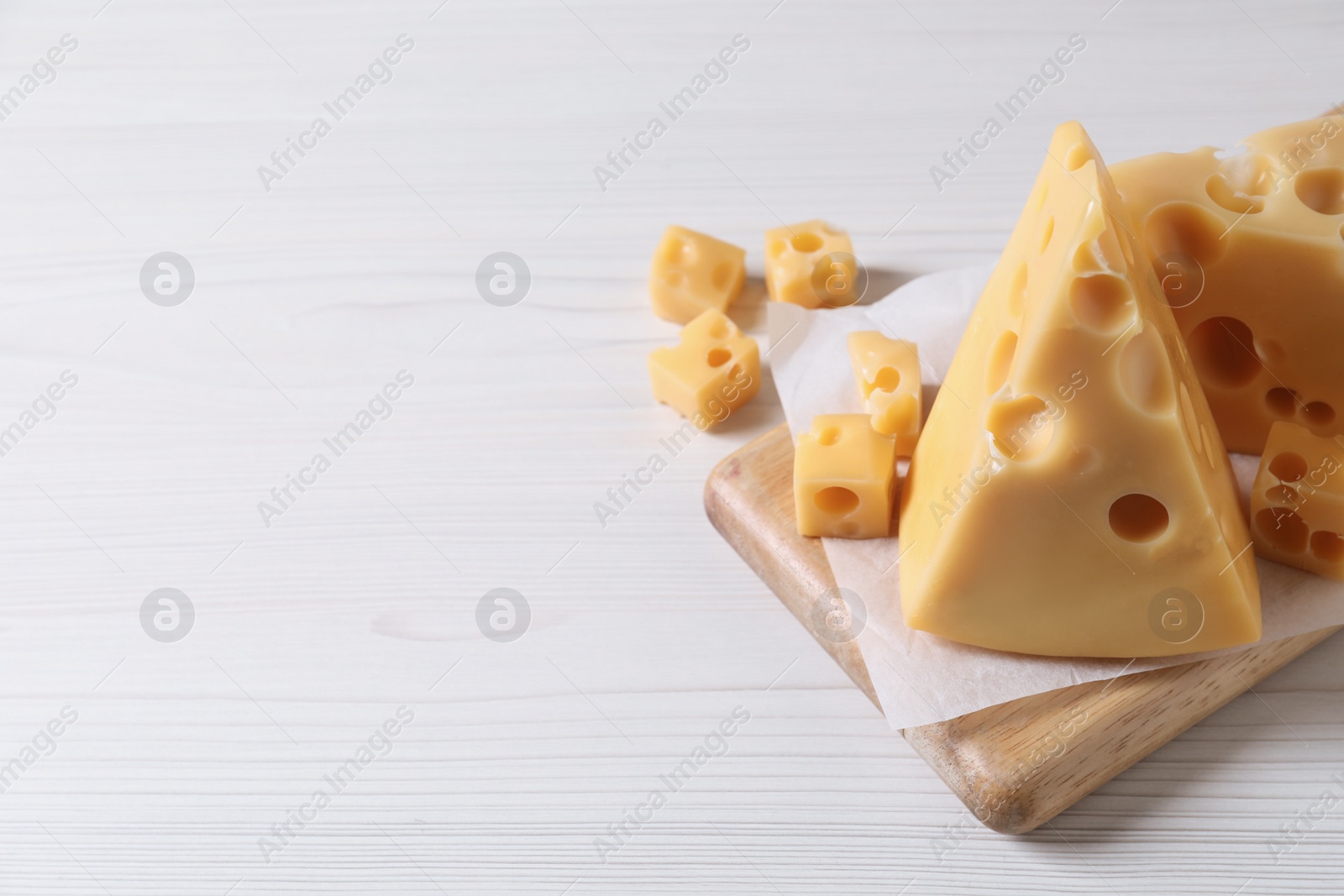 Photo of Tasty fresh cheese on white wooden table, closeup. Space for text