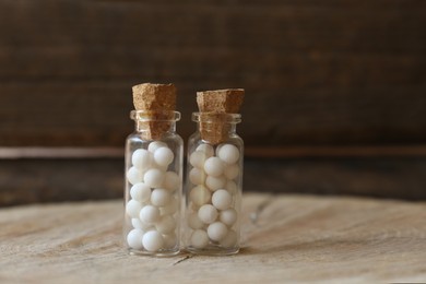 Photo of Bottles with homeopathic remedy on wooden stump