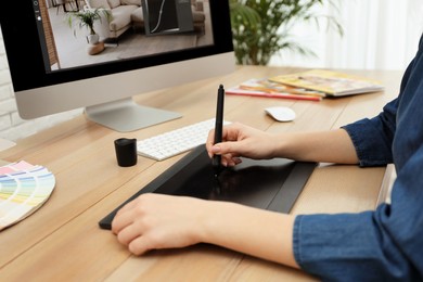 Professional retoucher working on graphic tablet at desk, closeup