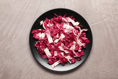 Photo of Cut radicchio in plate on grey table, top view