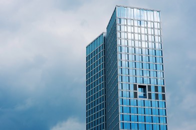 Photo of Modern multistory building against cloudy sky outdoors