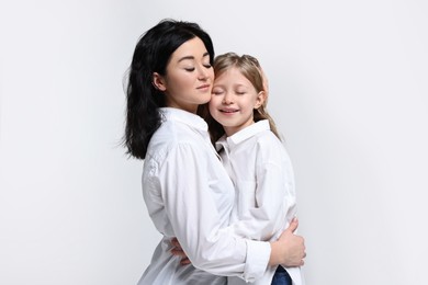 Photo of Beautiful mother with little daughter on white background