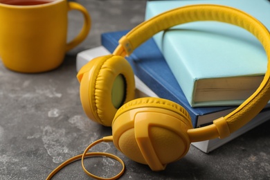 Photo of Modern headphones with hardcover books on table, closeup. Space for text